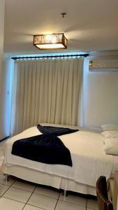 巴雷里尼亚斯Gran Lençóis Flat Barreirinhas的卧室在窗户前配有一张白色大床