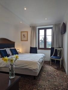 Saint-Amand-JartoudeixTrente-Trois Le Nouhaud的一间卧室配有一张床和两张蓝色椅子
