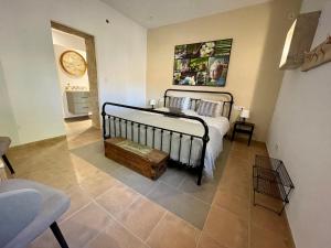 CarratracaEl bufon de la corte的卧室配有一张床,墙上挂着一个钟