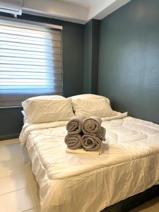 奥隆阿波CRIB 217 SUBIC BAY - Modern Fresh Condo的卧室内的一张带滚毛巾的床