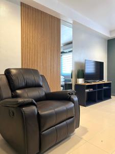 奥隆阿波CRIB 217 SUBIC BAY - Modern Fresh Condo的客厅里一张皮革躺椅,配有电视