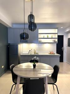 奥隆阿波CRIB 217 SUBIC BAY - Modern Fresh Condo的厨房配有桌椅和蓝色橱柜。