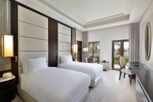 马斯喀特Al Bustan Palace, a Ritz-Carlton Hotel的酒店客房配有两张床和一张书桌
