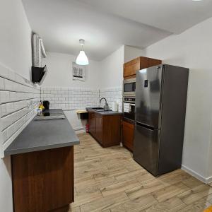 普鲁德尼克Apartament Tuwima 1的厨房配有不锈钢冰箱和木制橱柜