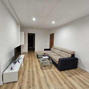 普鲁德尼克Apartament Tuwima 1的带沙发和电视的客厅