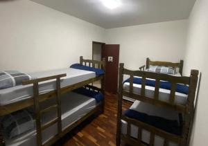 阿拉沙Apartamento até 8 pessoas Araxá Ótima localização的铺有木地板的客房内配有两张双层床。