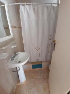 特尔马斯德里奥翁多Trujui Host的浴室设有白色的淋浴帘和水槽