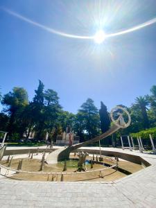 门多萨Habitación En España 1512的公园里有一个喷泉,阳光在天空中