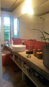 蒙得维的亚Seaside Serenity: Charming Countryside Cottage的一间带水槽和红色瓷砖墙的浴室