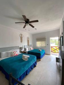 奥尔沃克斯岛Casa Coronaa Holbox México的一间卧室配有两张床和吊扇