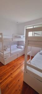 波尔图Owls Hostel Ribeiro的铺有木地板的客房内配有两张双层床。