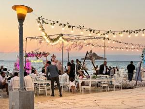 拉斯苏德尔Nozha Beach - Ras Sudr的一群人在海滩上参加婚礼时坐在桌子旁