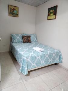 巴拿马城Apartamento a 10 minutos Aeropuerto Tocumen的一间卧室配有一张带蓝色棉被的床