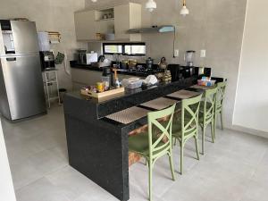 巴纳内拉斯Casa de Campo em Bananeiras-PB的厨房配有黑色柜台和绿色椅子