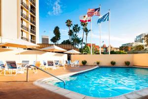 圣地亚哥圣地亚哥市中心小意大利福朋喜来登酒店 的一座带旗帜和桌椅的酒店游泳池