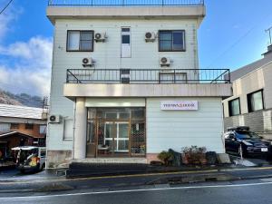 汤泽町Yuzawa House - Vacation STAY 07080v的一座白色的建筑,上面设有一个阳台