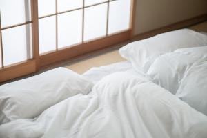 汤泽町Yuzawa House - Vacation STAY 07080v的带窗户的客房内一张带白色床单的未铺床