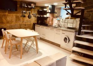 马林Casa Boutique Marín 1910的厨房配有桌子和洗衣机。
