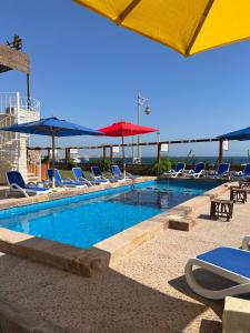 赫尔格达Lilly Lounge and Pool Accommodation for Adults Only的一个带椅子和遮阳伞的大型游泳池