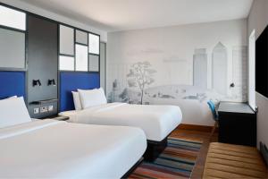 伦敦雅乐轩伦敦埃克塞尔酒店的酒店客房设有两张床和大窗户。