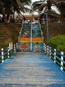 Puerto EscondidoCabaña Maríamar2的一条长长的蓝色木板路,上面有画