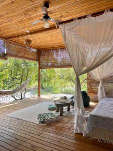 莫雷雷Casa Maiara (Eco friendly)的一间卧室配有一张床,甲板上配有吊床