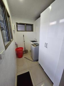 苏瓦FIJI HOME Apartment Hotel的一间厨房,在房间内配有洗衣机和烘干机