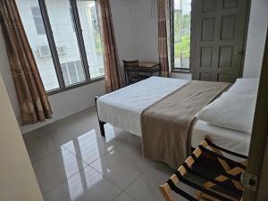苏瓦FIJI HOME Apartment Hotel的一间卧室设有床、两个窗户和一扇门