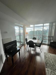 多伦多Downtown Toronto Suite By The Lake的客厅配有桌椅和钢琴