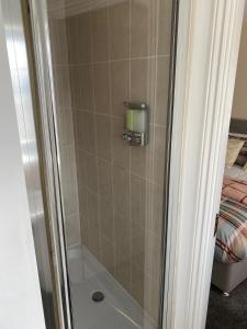 KentonOasis Abode @ Ashover Newcastle的一张床旁边的玻璃门淋浴
