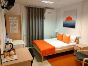 TengizBirlik的一间卧室配有一张带橙色毯子的床
