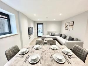 The HydeHolocene Luxury Apartments London的用餐室以及带桌椅的起居室。