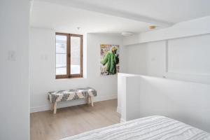 蒙特利尔Le Nomade MTL的白色的卧室设有床和窗户