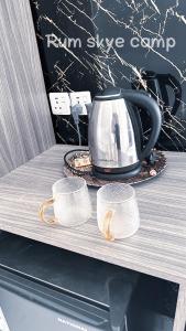 瓦迪拉姆Rum Skye camp的茶壶和两杯放在架子上