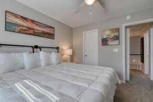 默特尔比奇1408 Perrin Dr, Unit A - Ocean Walk Sleeps 8的卧室配有一张白色大床和吊扇
