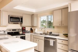 圣地亚哥2BR Retreat w/ Balcony Views in Central San Diego!的厨房配有白色橱柜和不锈钢用具