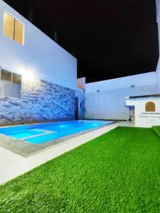 伊察Casa Privada de Estreno con Piscina en Ica的一座绿草环绕的游泳池