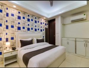 新德里Hotel Galaxy Stay B&B的一间卧室设有一张大床,墙上有蓝色的方形