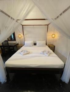 阿鲁甘湾Agra Arugambay的帐篷内的一张床位,上面有两条毛巾