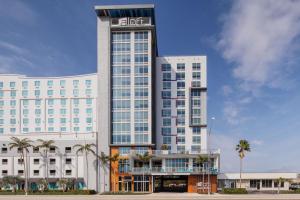 劳德代尔堡Aloft Fort Lauderdale Airport & Cruise Port的一座大型酒店建筑,前面有棕榈树