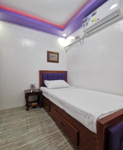 卡瓦延市Homelux Transient House的一间小卧室,配有一张床和空调