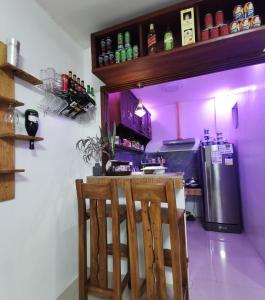 卡瓦延市Homelux Transient House的紫色的厨房,配有酒吧和冰箱