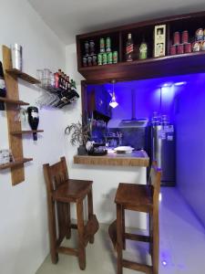 卡瓦延市Homelux Transient House的一个带两把椅子的厨房和一个带紫色照明的酒吧