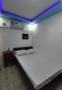卡瓦延市Homelux Transient House的卧室配有白色床和蓝色天花板