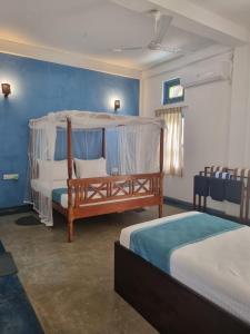 科斯戈德Darshana Beach Hotel的一间卧室配有两张床和一张天蓬床。