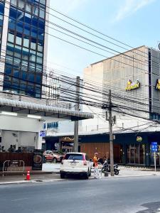 班敦孟Luna hotel สถานีดอนเมือง的停在大楼前的白色汽车