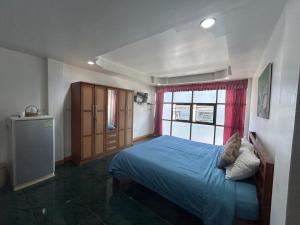 南芭堤雅Coffeeandbeer的一间卧室设有蓝色的床和窗户。