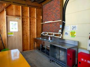 白马村G-4 Gramping Sauna 白馬森のわさび農園的厨房设有水槽和砖墙