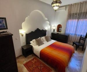 卡萨布兰卡达尔塔拉酒店的一间卧室配有一张大床和色彩缤纷的毯子