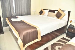 德奥加尔Hotel Buddha Vibrant的一间卧室配有一张带白色床单的大床